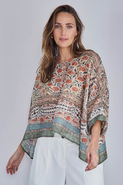 Model Tegand wearing size 10 of the Marrakech Cape Top - Greenfleur in colour Greenfleur, in a cropped view