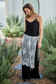 Model Tegand wearing size 10 of the Last Dance Lace Overlay Skirt - White in colour White, from the front