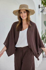 Model Tegand wearing size 10 of the Out Of Office Woven Cotton Shrug  - Chocolate in colour Chocolate, in a cropped view