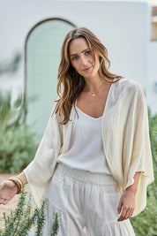 Model Tegand wearing size 10 of the Out Of Office Woven Cotton Shrug  - Sand in colour Sand, in a cropped view