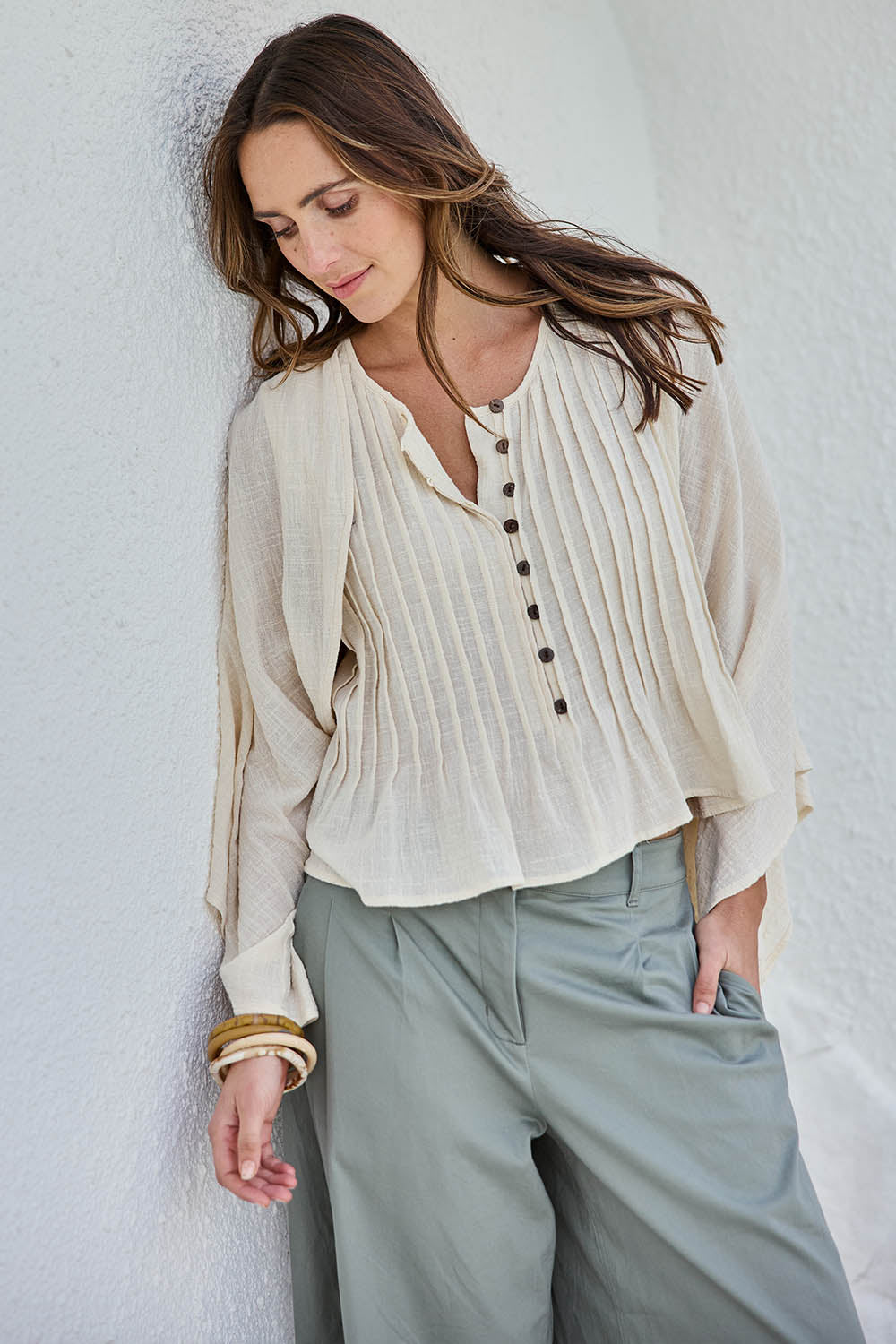Model Tegand wearing size 10 of the Out Of Office Woven Cotton Shrug  - Sand in colour Sand, in a cropped view