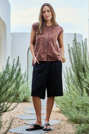 Model Tegand wearing size 10 of the Out Of Office Woven Cotton Longline Shorts - Black in colour Black, from the front