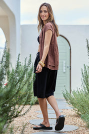 Model Tegand wearing size 10 of the Out Of Office Woven Cotton Longline Shorts - Black in colour Black, from the front