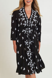 Model Chanel wearing size 16 of the Dancing With Birds Midi Dress in colour Black (Black), from the front, cropped image