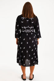 Model Monique wearing size 14 of the Dancing With Birds Midi Dress in colour Black (Black), from the back