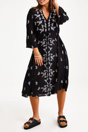 Model Monique wearing size 14 of the Dancing With Birds Midi Dress in colour Black (Black), from the front, cropped image