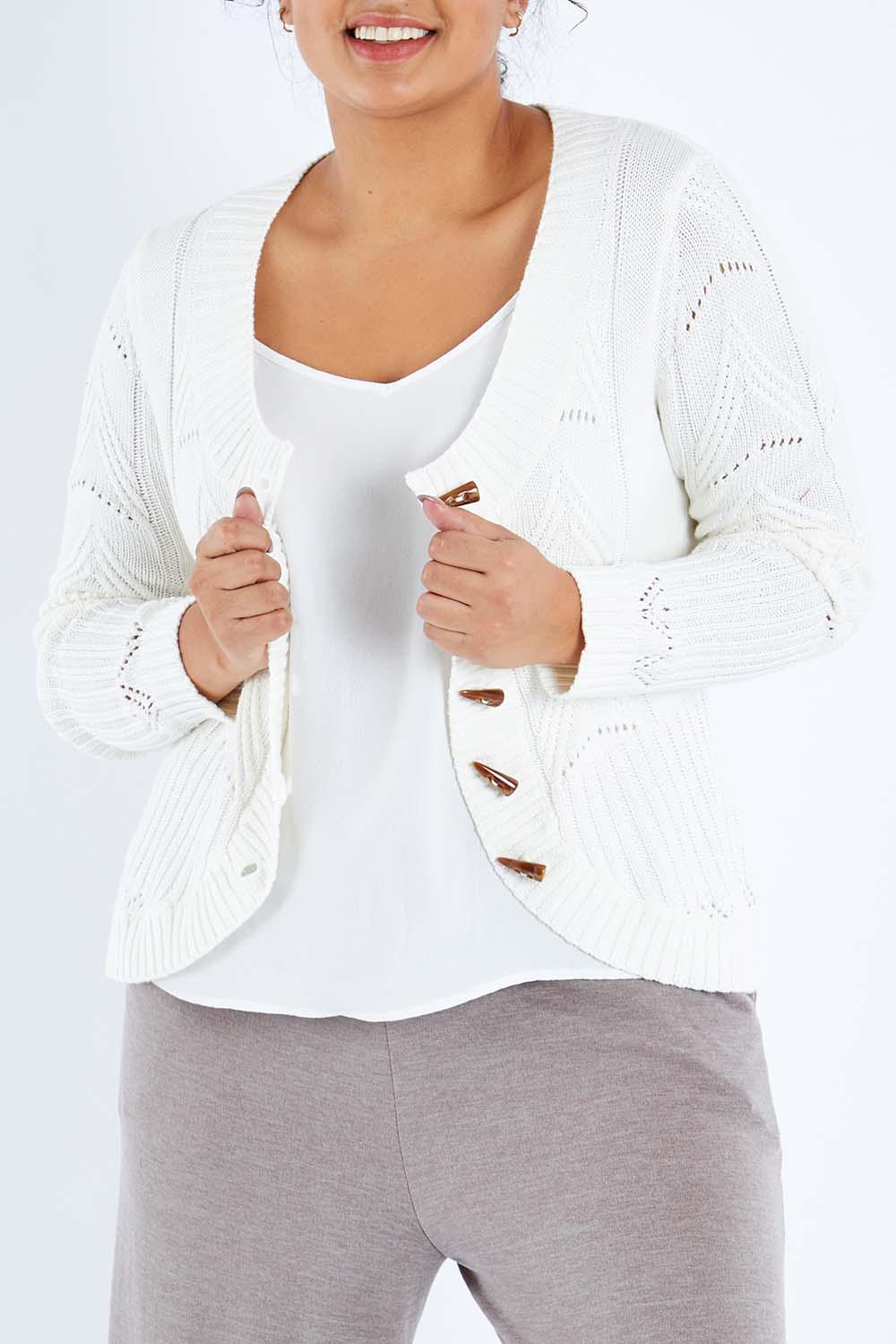 Model Sasha-Lee wearing size XL of the Fireside Button Cardigan in colour Snow (White), from the front, cropped image