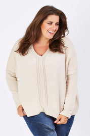 Model Mae wearing size XL of the Yeye Slouch Jumper in colour Sandy, from the front, cropped image