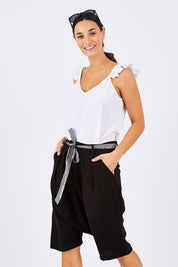 Model Georgia wearing size 10 of the Moped Cruising Shorts in colour Black (Black), from the front, cropped image