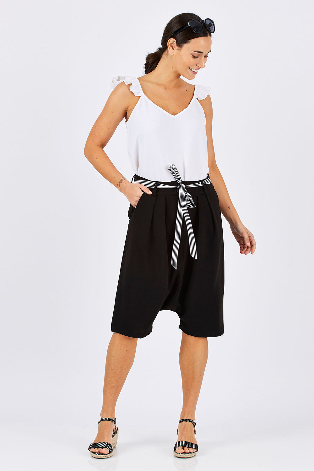 Model Georgia wearing size 10 of the Moped Cruising Shorts in colour Black (Black), from the front, showing the whole outfit