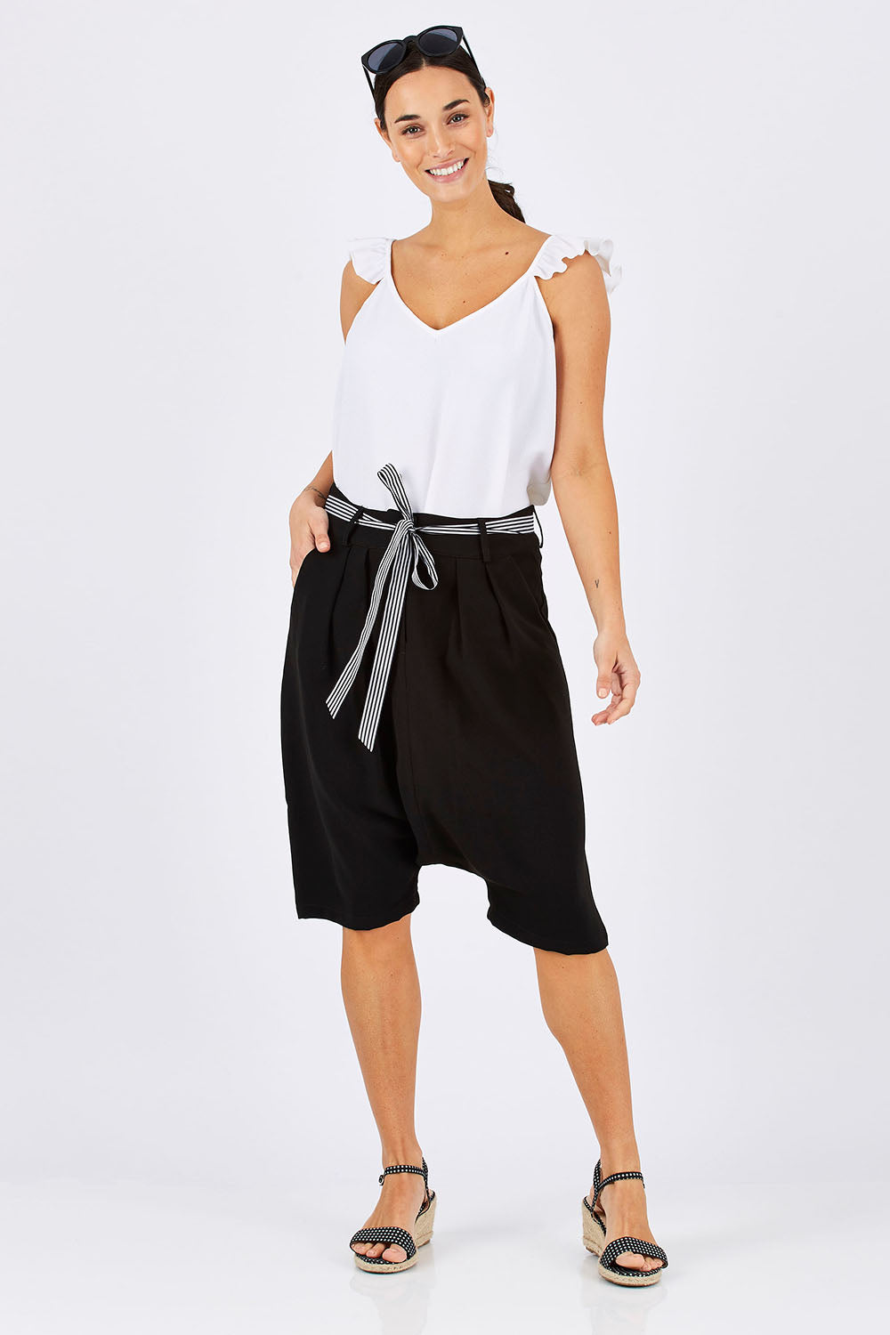 Model Georgia wearing size 10 of the Moped Cruising Shorts in colour Black (Black), from the front, showing the whole outfit