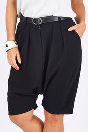 Model Laura wearing size 12 of the Moped Cruising Shorts in colour Black (Black), from the front, cropped image