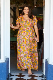 Model Mae wearing size 18 of the Bellezza Maxi Dress in colour Sunset, from the front, showing the whole outfit