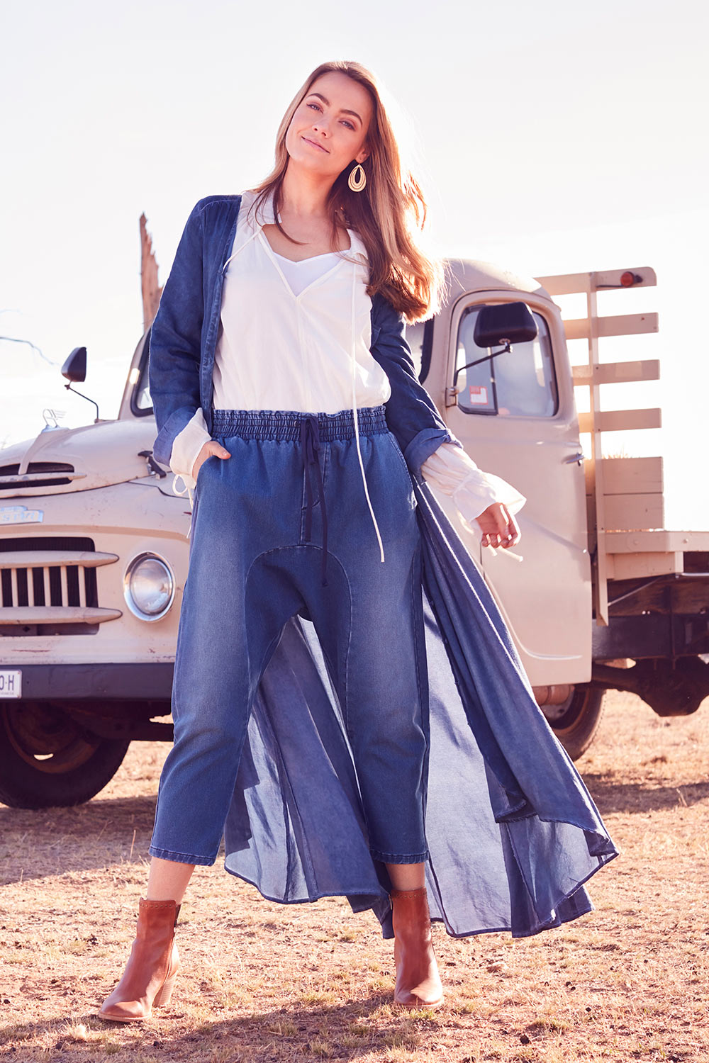 Model Marnee wearing size 10 of the Just Chillin Stretch Dropped Crotch Jeans in colour Denim (Blue), from the front, showing the whole outfit