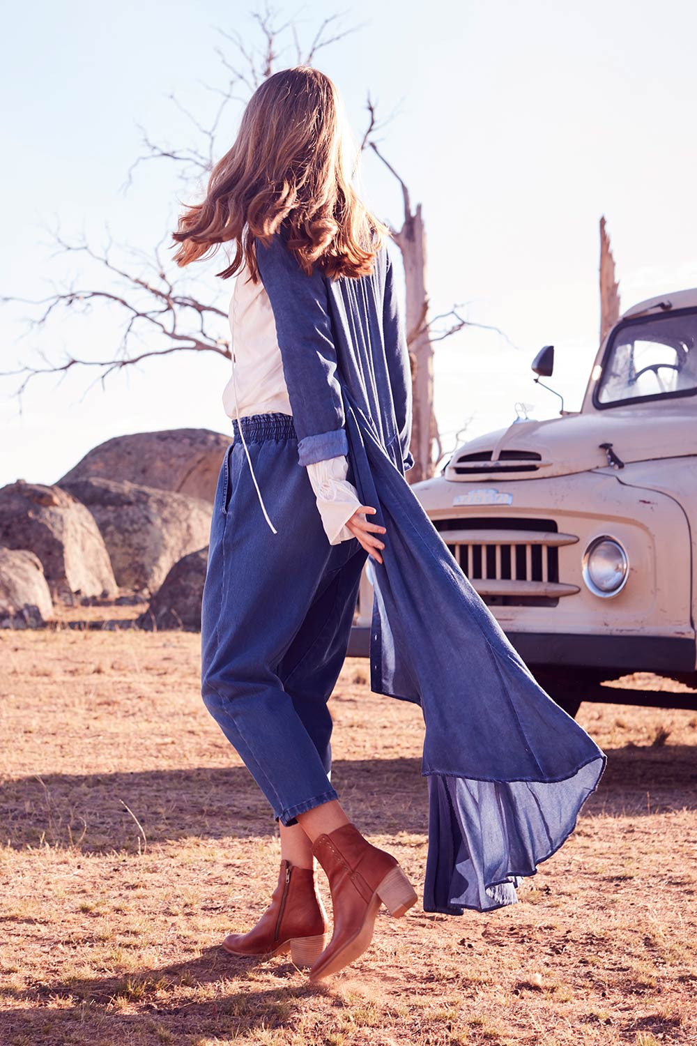 Model Marnee wearing size 10 of the Just Chillin Stretch Dropped Crotch Jeans in colour Denim (Blue), from the front, showing the whole outfit