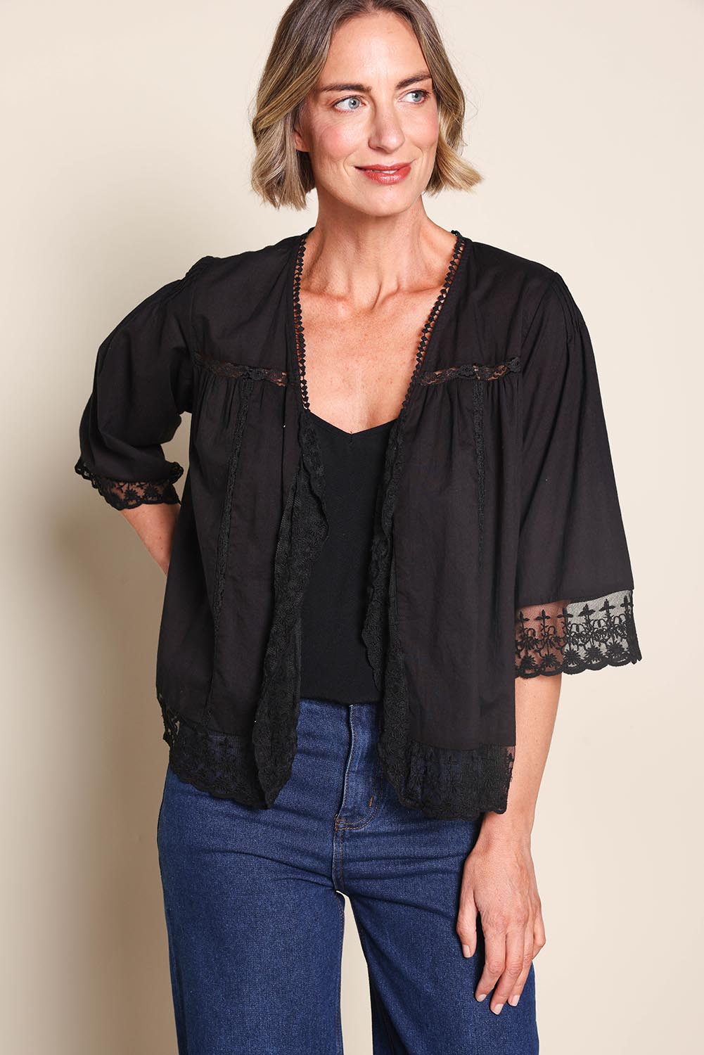 Model Riinar wearing size 10 of the Spring Day Cotton Throw - Black in colour Black, in a cropped view