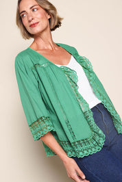 Model Riinar wearing size 10 of the Spring Day Throw – Green in colour Green, from an angle