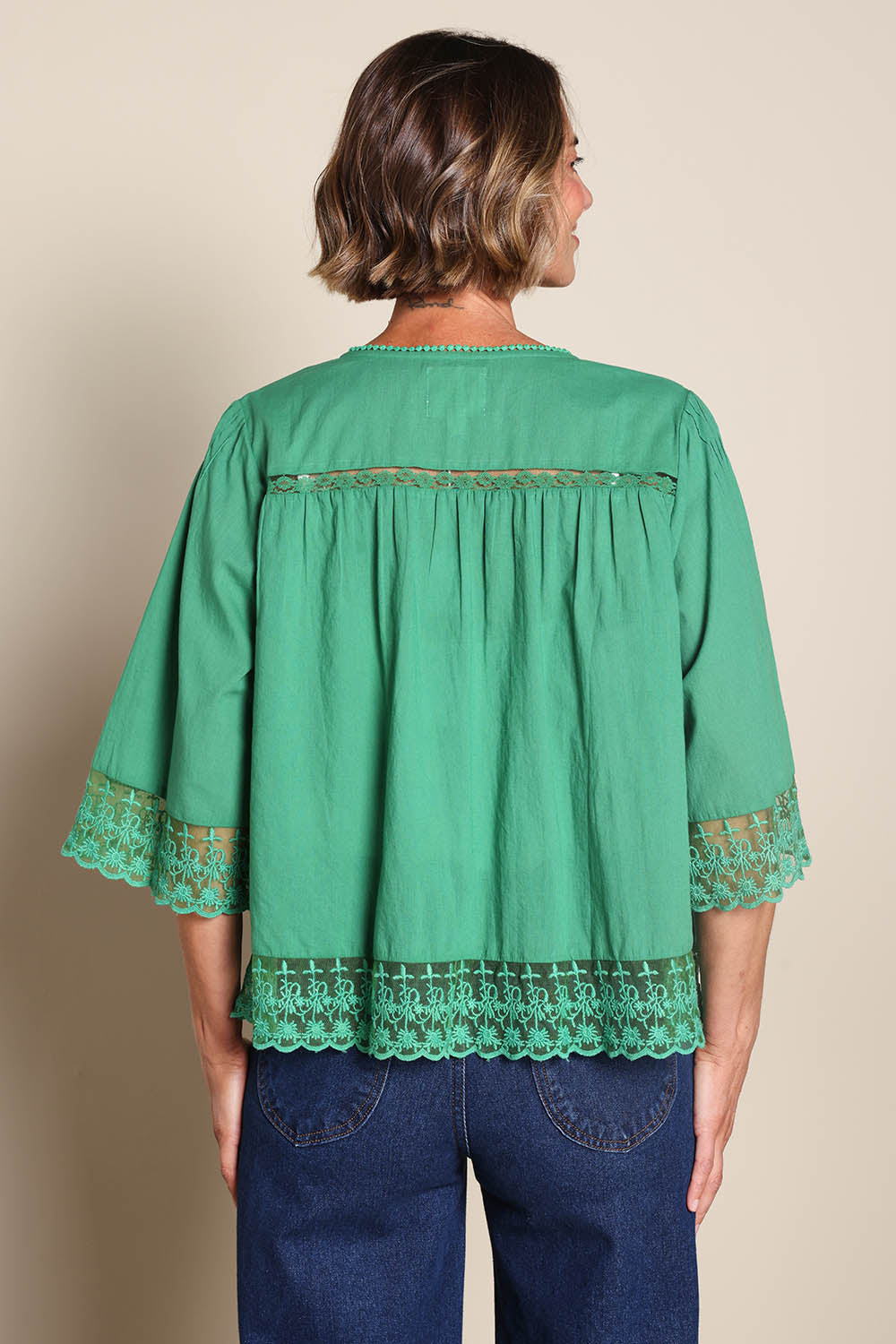 Model Riinar wearing size 10 of the Spring Day Throw – Green in colour Green, from the back