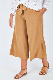 Model Fiona wearing size 16 of the Coyote Wide Leg Linen Blend Pant in colour Camel, from the front, cropped image