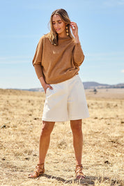 Model Tegan wearing size 10 of the Snuggle Up Jumper in colour Coffee, from the front, showing the whole outfit