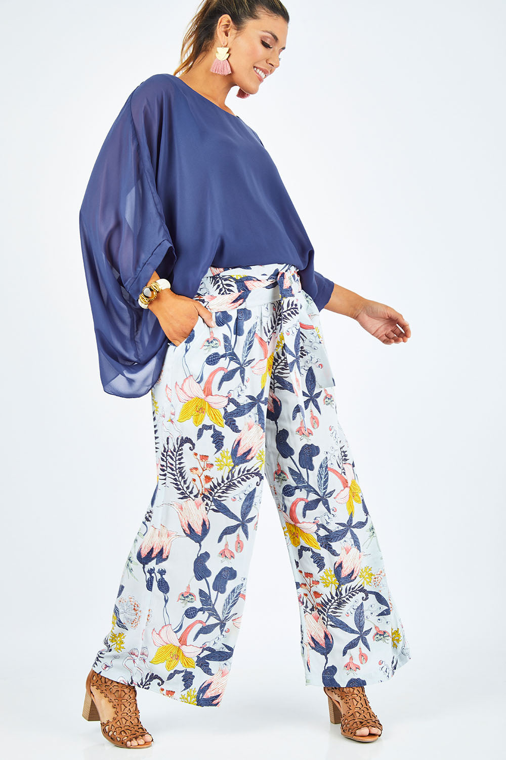 Model Palatina wearing size 14 of the Flowers For Me Pants in colour Flowerfall (Blue), from the front, showing the whole outfit