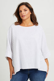 Model Monique wearing size 14 of the Joy And Laughter Slouch Top in colour Whitestrip (White), from the front, cropped image