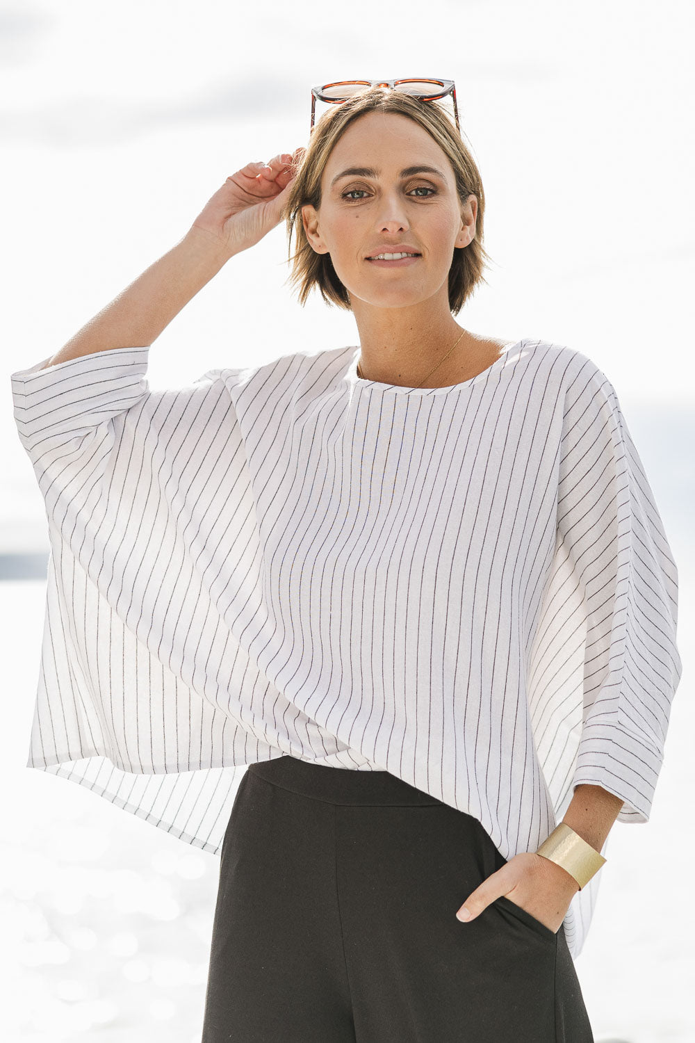 Model Tegan wearing size 10 of the Joy And Laughter Slouch Top in colour Whitestrip (White), from the front, showing the whole outfit