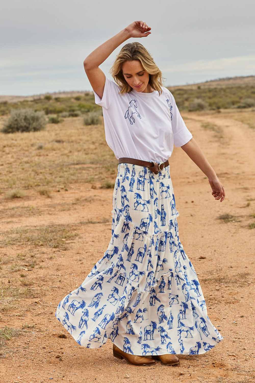 Model Tegan wearing size 10 of the Skirting Around The Garden Skirt in colour Whitehorse (White), from the front, showing the whole outfit