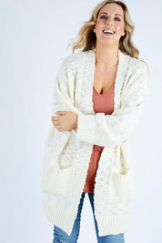 Model Jess wearing size L of the Mountain Dreaming Cardi in colour Cream (White), from the front, cropped image
