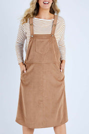 Model Jess wearing size 14 of the My Cord Pinafore Dress in colour Camel, from the front, cropped image