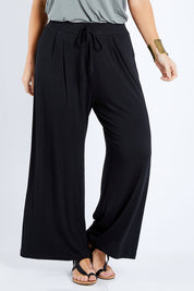 Model Laura wearing size 12 of the Softly Swinging Bamboo Pants in colour Black (Black), from the front, cropped image