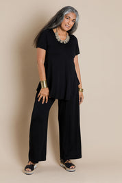 Model Nadine wearing size 10 of the Softly Swinging Bamboo Pants in colour Black (Black), from the front, showing the whole outfit
