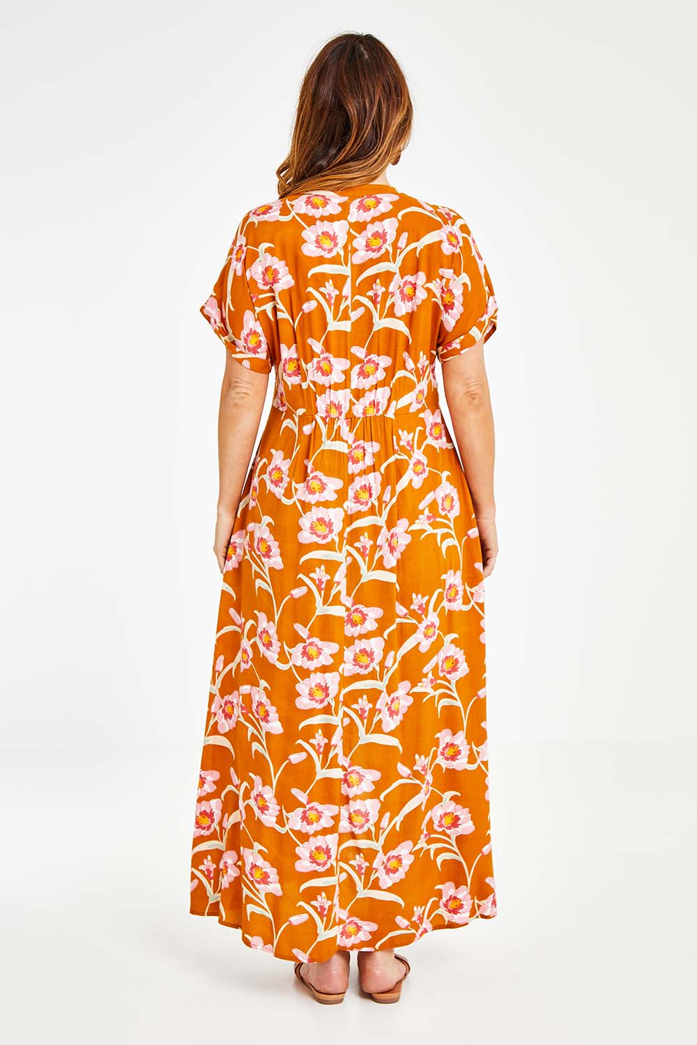 Model Laura wearing size 14 of the Wild Garden Maxi Dress in colour Caramel, from the back