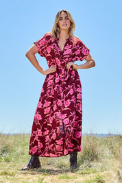 Model Tegan wearing size 10 of the Wild Garden Maxi Dress in colour Plumfleur (Pink), from the front, showing the whole outfit