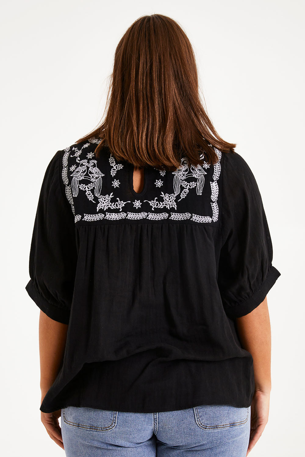 Model Monique wearing size 14 of the Secret Garden Cotton Blouse in colour Black (Black), from the back