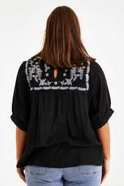 Model Monique wearing size 14 of the Secret Garden Cotton Blouse in colour Black (Black), from the back