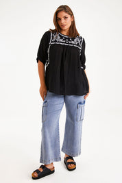 Model Monique wearing size 14 of the Secret Garden Cotton Blouse in colour Black (Black), from the front, showing the whole outfit