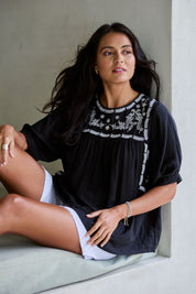 Model Tahnee wearing size 10 of the Secret Garden Cotton Blouse in colour Black (Black), from the front, showing the whole outfit