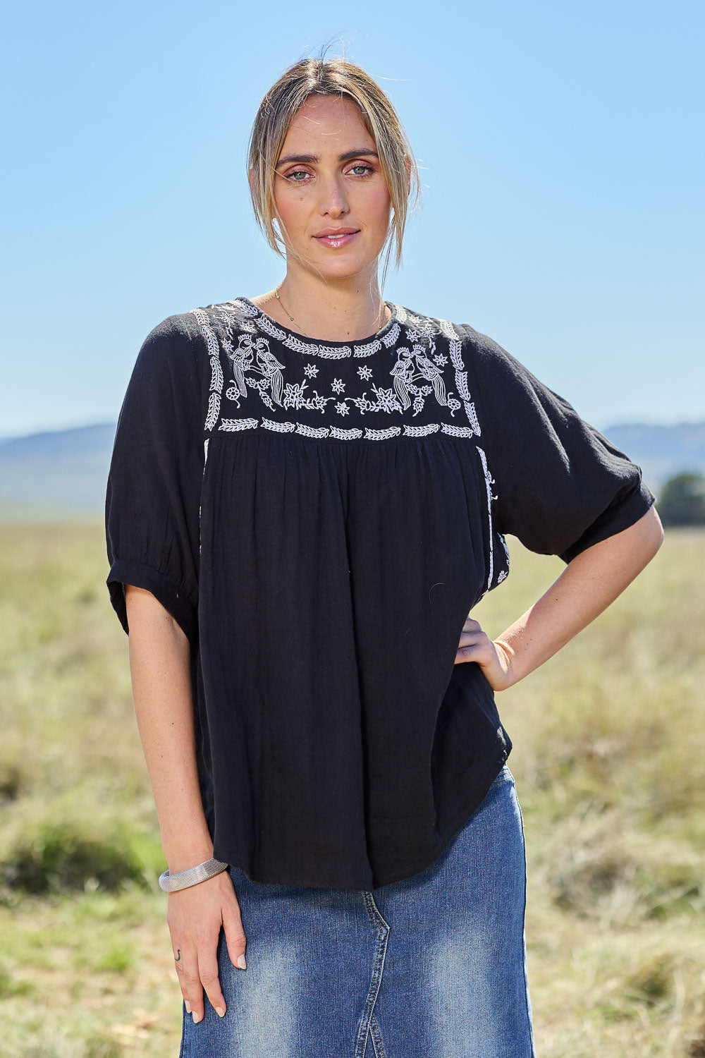 Model Tegan wearing size 10 of the Secret Garden Cotton Blouse in colour Black (Black), from the front, showing the whole outfit