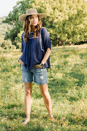 Model Ilona wearing size 10 of the Secret Garden Cotton Blouse in colour Deepblue (Blue), from the front, showing the whole outfit