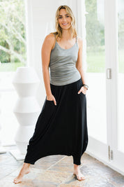 Model Tegan wearing size 10 of the Softly Swinging Bamboo Harem Pants in colour Black (Black), from the front, showing the whole outfit