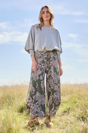 Model Tegan wearing size 10 of the Good Vibes Balloon Hem Pants in colour Greenpais (Green), from the front, showing the whole outfit