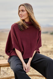 Model Tegan wearing size S of the Knit Pick Throw Sweater in colour Wine (Purple), from the front, showing the whole outfit