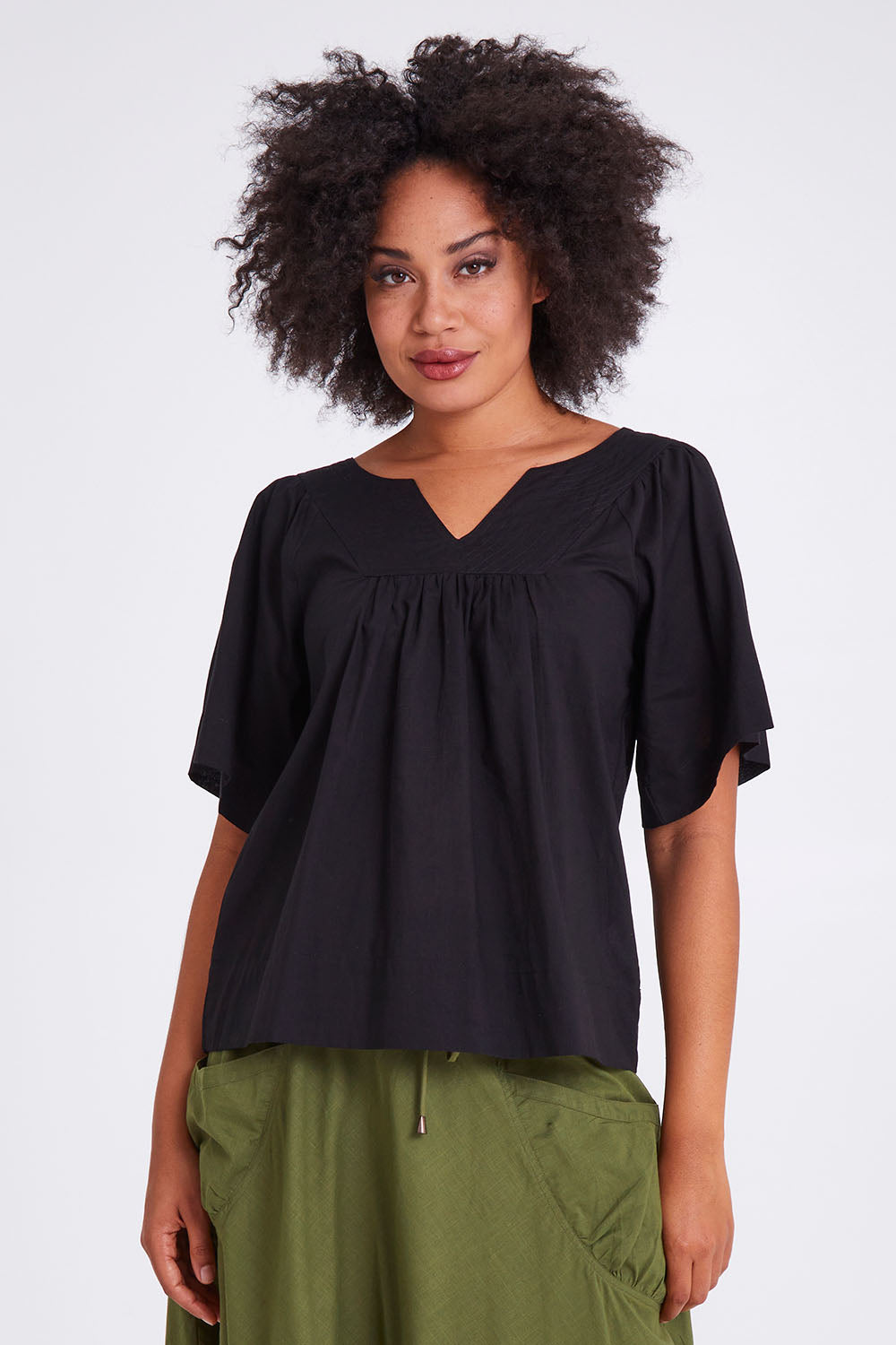 Model Olivia wearing size 10 of the Freya Top in colour Black (Black), from the front, cropped image
