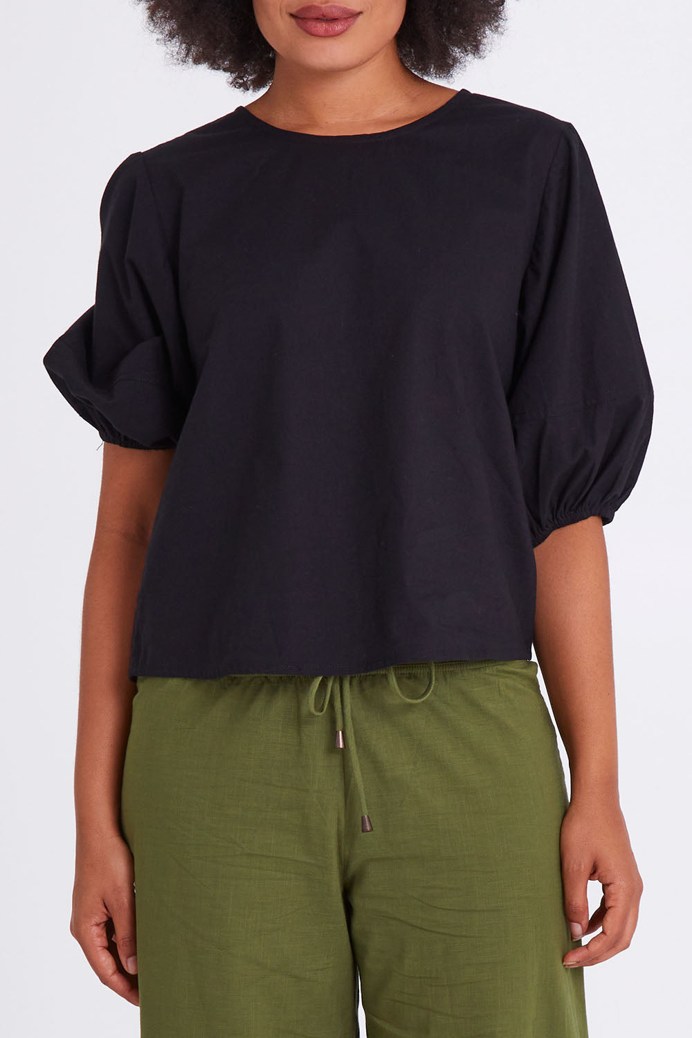 Model Olivia wearing size 10 of the Ava Top in colour Black (Black), from the front, cropped image