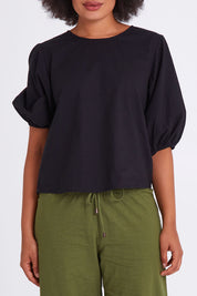 Model Olivia wearing size 10 of the Ava Top in colour Black (Black), from the front, cropped image