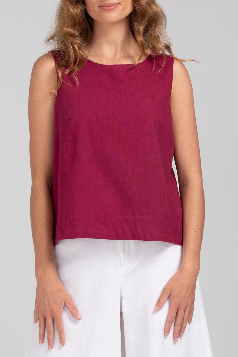 A model wearing the Hara Cotton Top in colour Magenta (Purple), from the front, cropped image