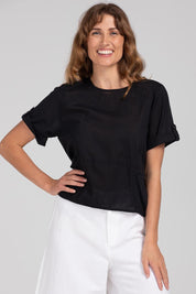 A model wearing the Guru Cotton Top in colour Black (Black), from the front, cropped image