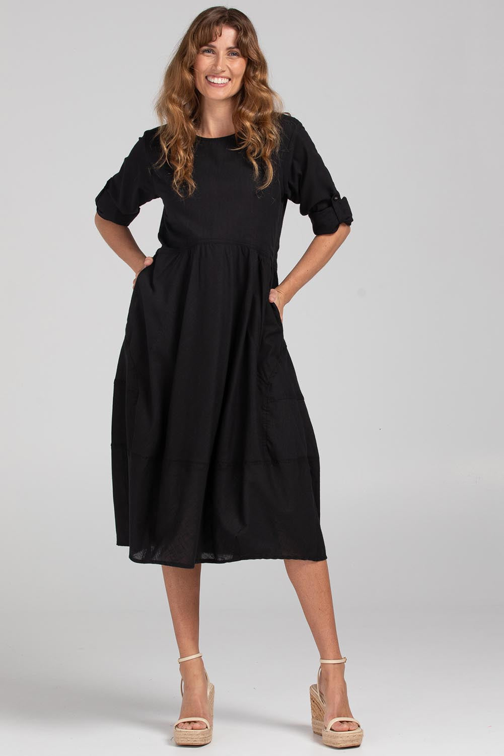 A model wearing the Guru Cotton Dress in colour Black (Black), from the front, showing the whole outfit