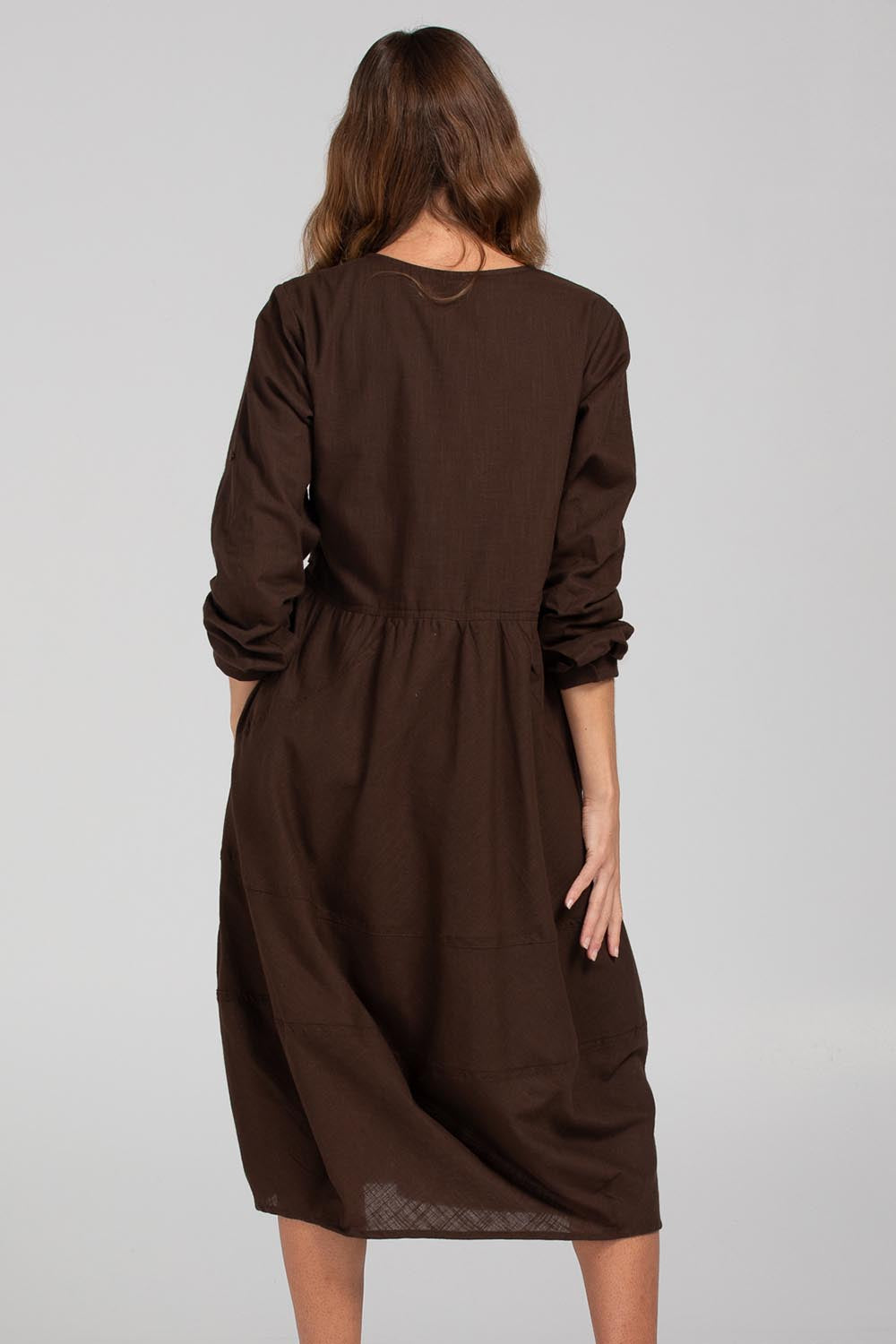 A model wearing the Guru Cotton Dress in colour Coffee, from the back